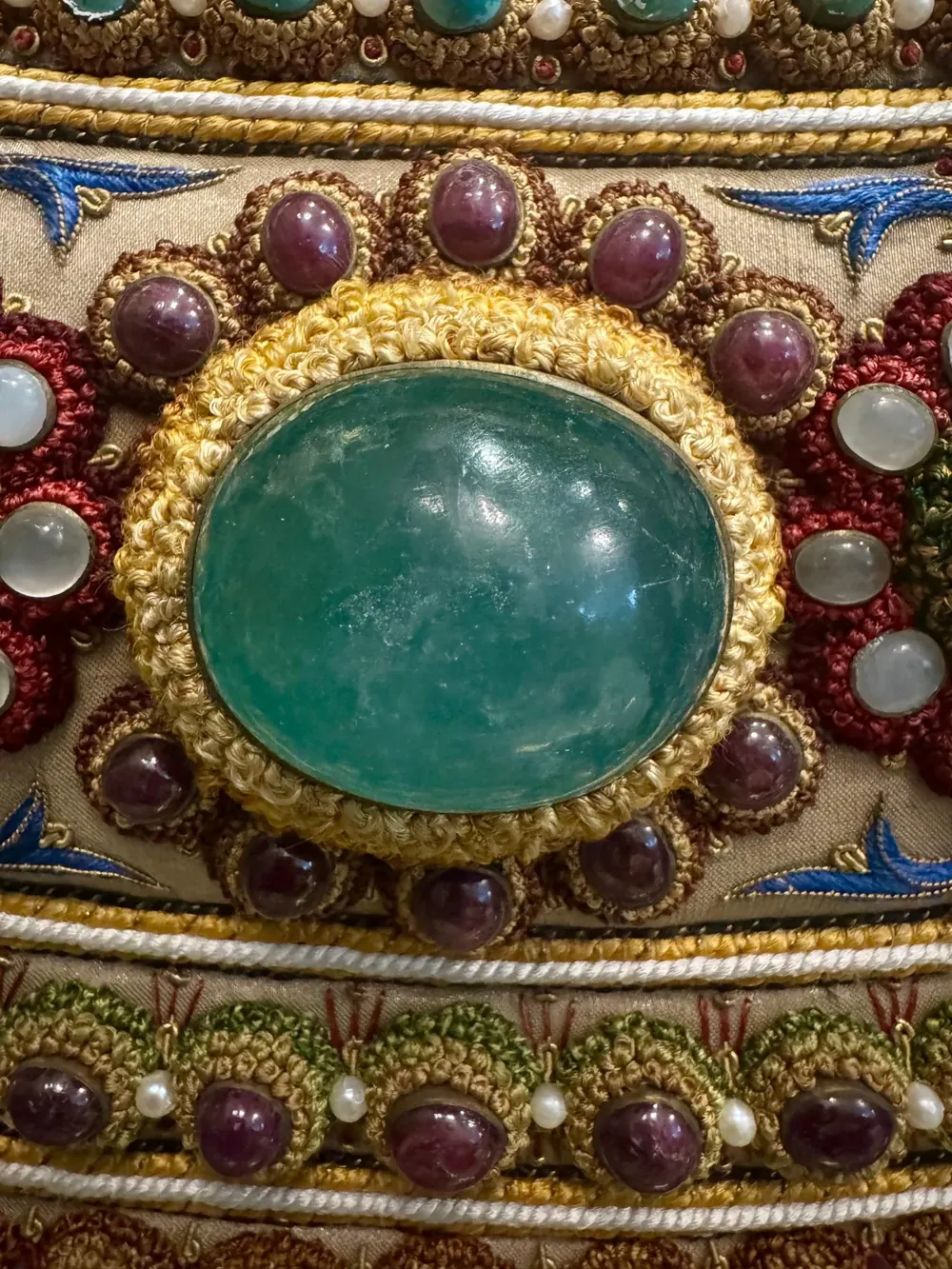 An emerald cabochon in a mount of coiled thread