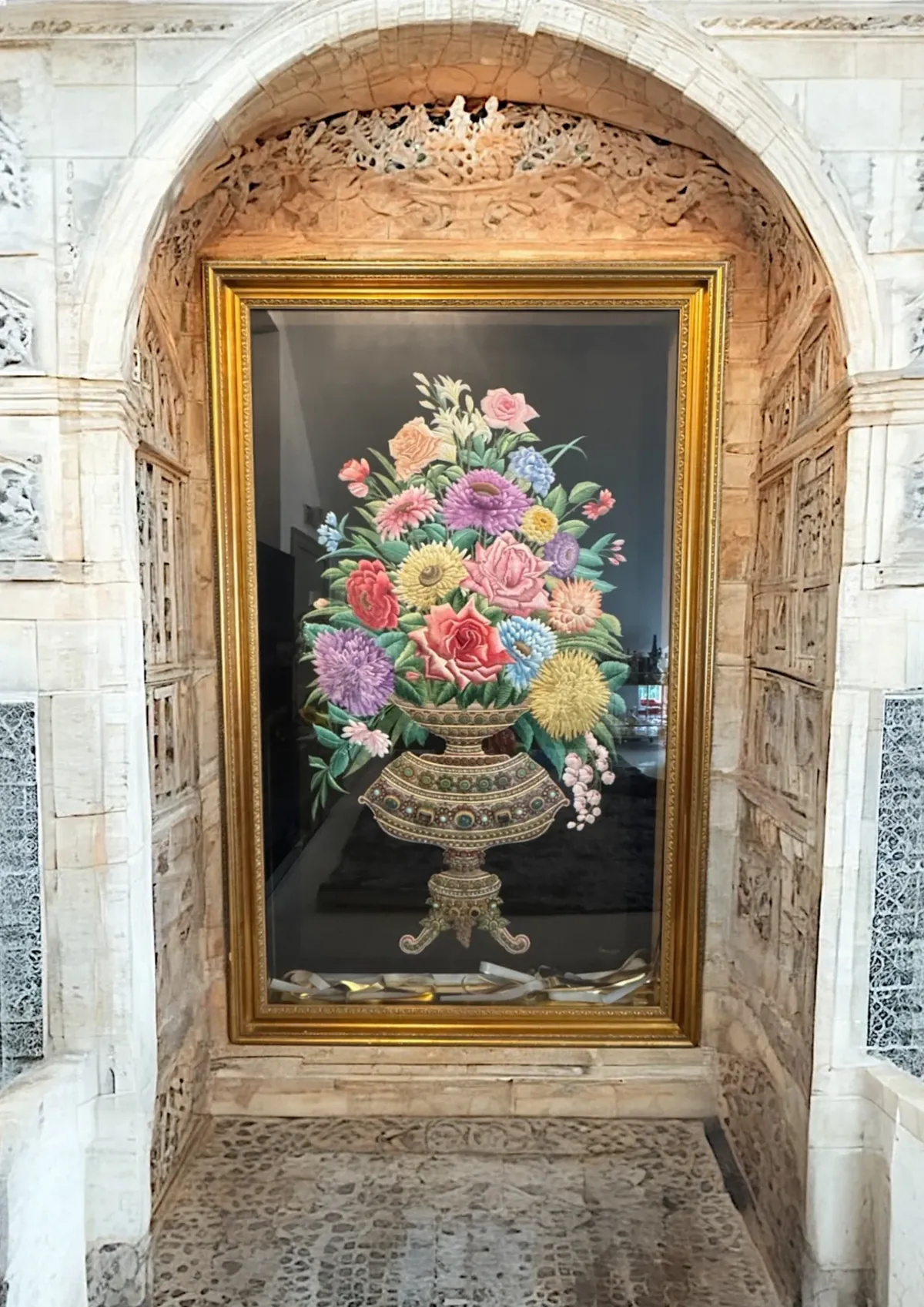 The Vase in its gilded frame inside a carved stone niche
