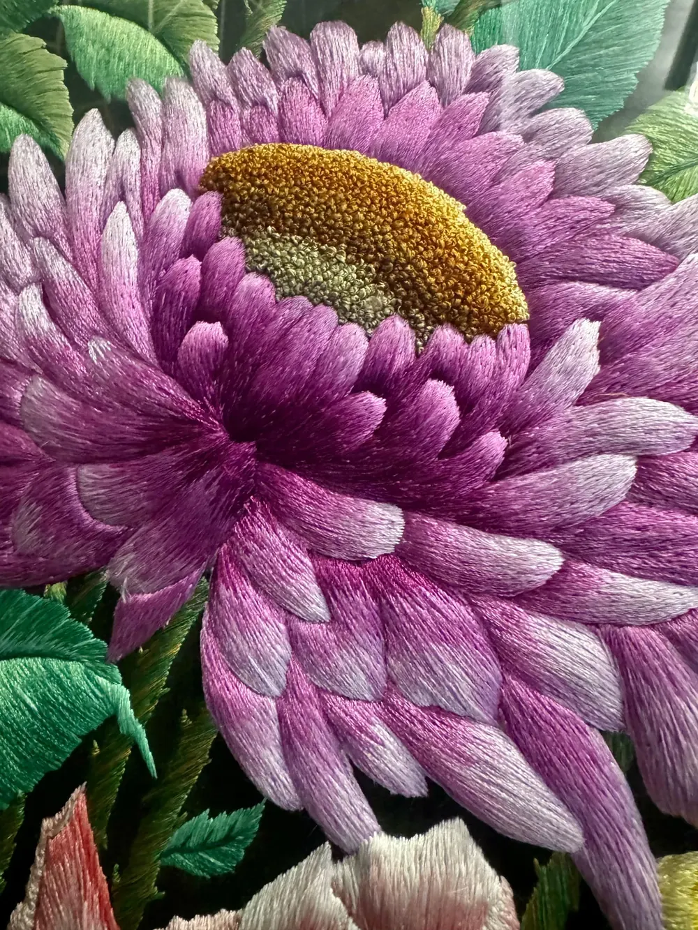 A violet bloom worked in silk